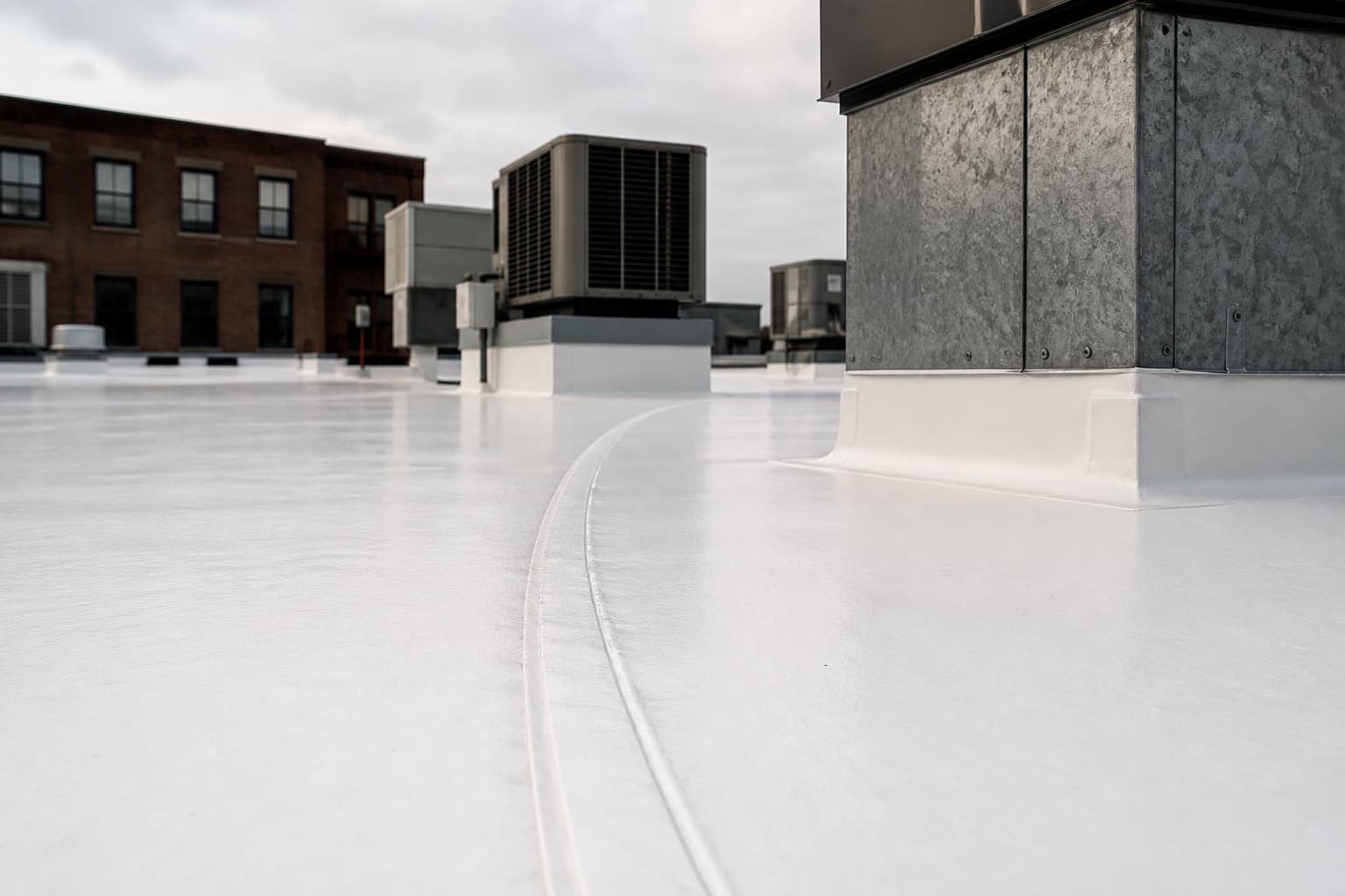Close view of a heat-welded seam on a white TPO commercial roof